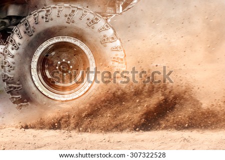 Motion the wheels tires and off-road that goes in the dust of the desert through the wheels on the sand