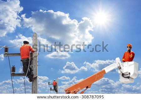 Engineer in a bucket high up of a crane truck use radio communication for command working to electricians at the pole