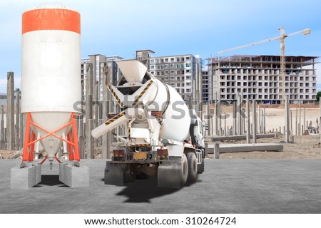 Cement mixer truck parked in front of a new building under construction with precast concrete piles