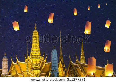 Thai\'s Family release sky lanterns to worship buddha\'s relics in night at The Buddhist temple of Wat Phra Kaeo at the Grand Palace in Bangkok, Thailand