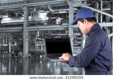 Mechanic working on a computer connected to a machine for maintenance at Industrial steel pipelines and boiler of power plant