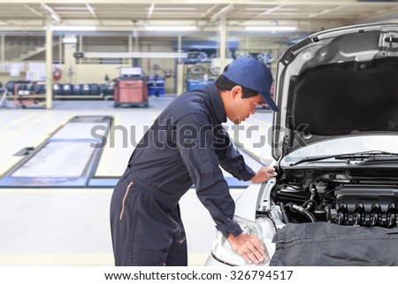 Car mechanic looking at engine for analysis symptoms of car at maintenance repair service station