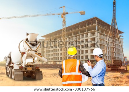 Civil engineer and foreman control working at a construction high building area