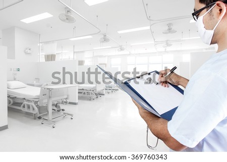 Doctor writing clipboard for diagnosis in aided the recovery room with modern equipment and comfortable equipped in hospital