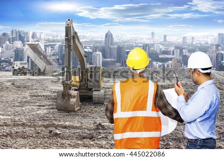 Engineer and Foreman looking plan for control working with excavator on a construction site against urban scene