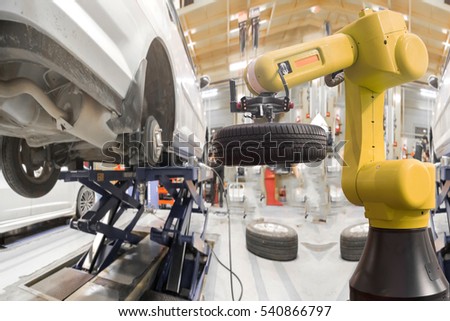 Robot arm for automotive engineering changing car wheel in modern auto repair shop