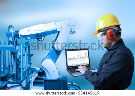 Industry concept and blue tone of Engineer programing automated robot arm in production line of smart factory