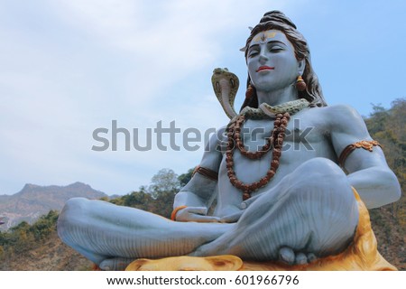 Beautiful statue of meditating Shiva. Lord Shiva sits near the Ganges River at the foot of the Himalayas in Rishikesh, India. Yoga and meditation concept.