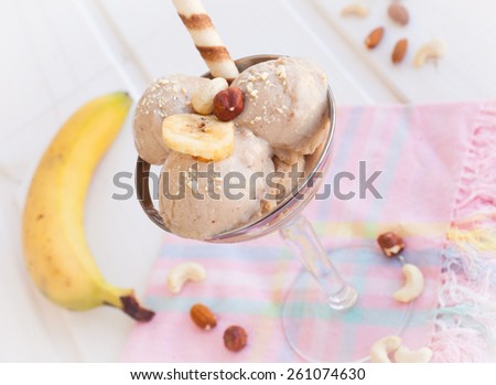 Homemade banana ice cream decorated crushed nuts