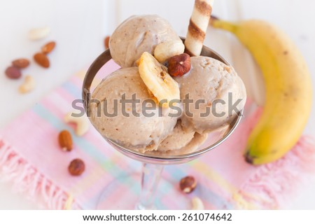 Homemade banana ice cream decorated crushed nuts