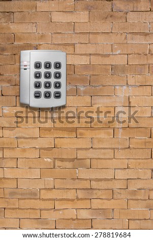 Security entrance touch pad on  brick wall