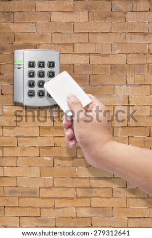 hand use key card  for Security entrance pad on  brick wall
