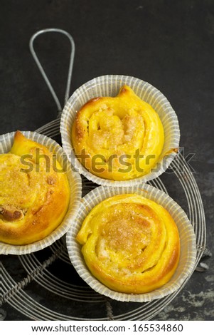 Homemade saffron buns with almond paste filling on a baking tray and trivet