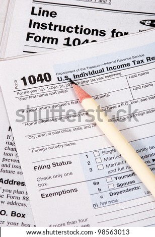 Close up of United States tax form, instruction book and pencil