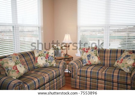 Two plaid couches with floral pillows