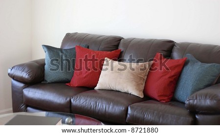 Comfortable brown leather couch with pillows