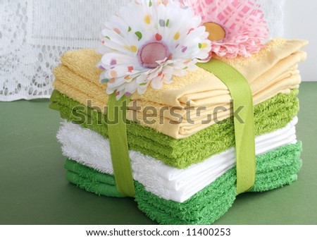 Green and yellow towels wrapped with ribbon and flowers