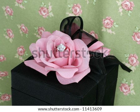 Black velvet box,pink rose, and diamond ring.