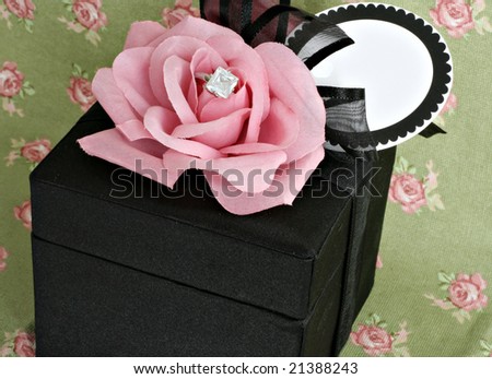 Pink rose on black velvet box with diamond ring