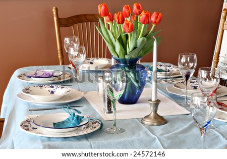 Beautiful dinner table with china and tulips