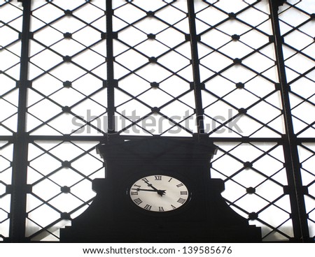 Old clock on a window of the train station in Seville, Spain