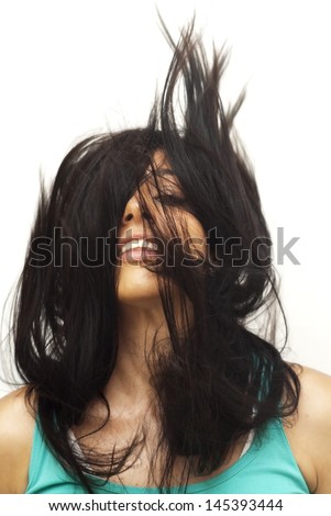Portrait of a young  woman with green shirt and her hair in the wind over white background