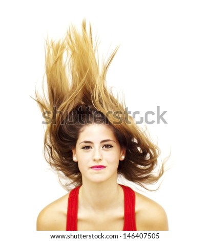 Portrait of a young  woman with red shirt and her hair in the wind over white background