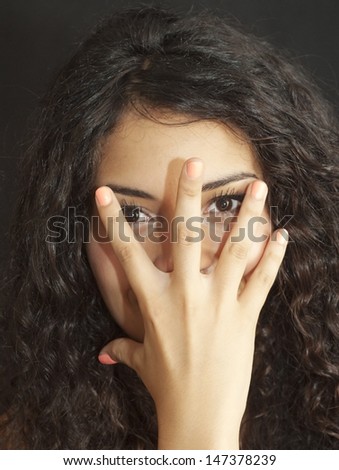 Portrait of an attractive woman, with hand on face, on black background