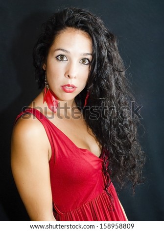 Wonderful latin woman with red dress on black background