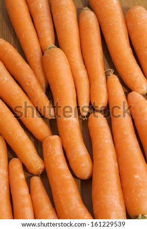 Tasty raw carrots on a wooden tray