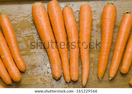 Tasty raw carrots on a wooden tray
