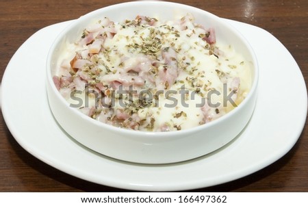 Dinner plate of bacon with melted cheese and other species