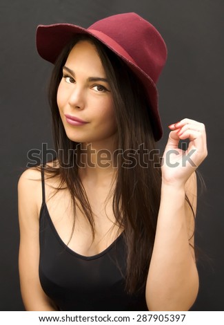 Portrait of Beautiful Young Woman With Red  Hat Over Black Background