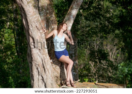 Young beauty woman posing at big tree in jungle forest of Koh Samui
