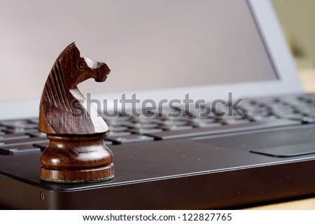 Closeup of chess knight on laptop