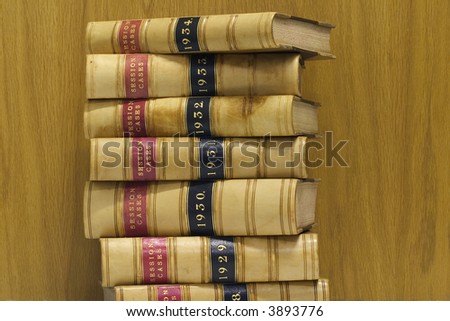 A stack of old law reports against a wood background