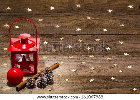candle lamp, ornament, cinnamon and cones on starry old wooden