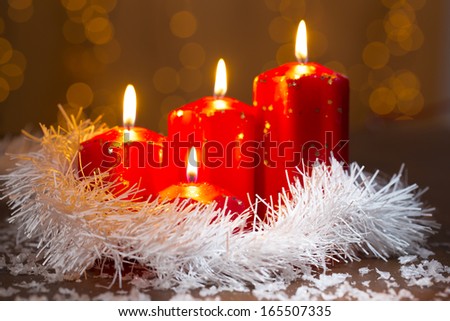 advent candles with white boa in front of shiny background