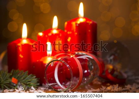 advent candles with champagne glass and bell in front of shiny b