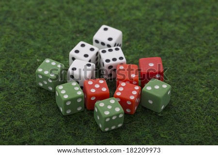 white, green and red dices on green baize