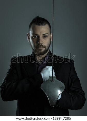 Handsome man with sword fencing and white gloves