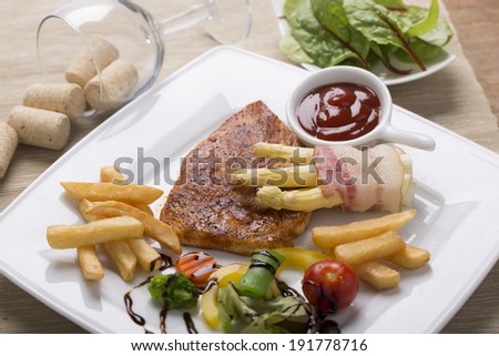 grilled chicken breast with French fries, asparagus, and vegetables