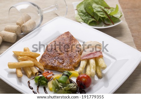 grilled chicken breast with French fries, asparagus, and vegetables