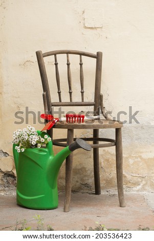 garden still life with chair, garden tools and watering can