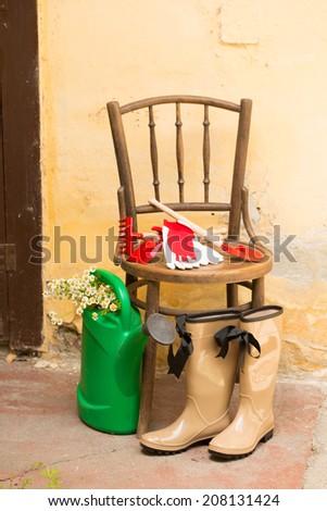 garden still life with gum boots, watering can and garden tools