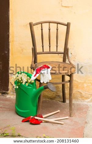 garden still life with chair, watering can and garden tools