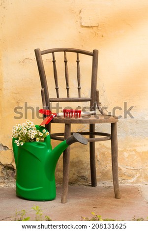 garden still life with chair, garden tools and watering can
