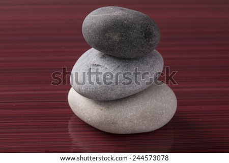 Wellness spa stones before shining burgundy background