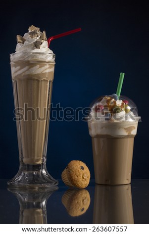 ice coffee in glass and plastic takeaway cup, decorated with whipping cream and bon-bons, advertisement for menu card