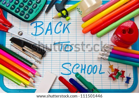 This is a white and blue slate with various colorful school supplies